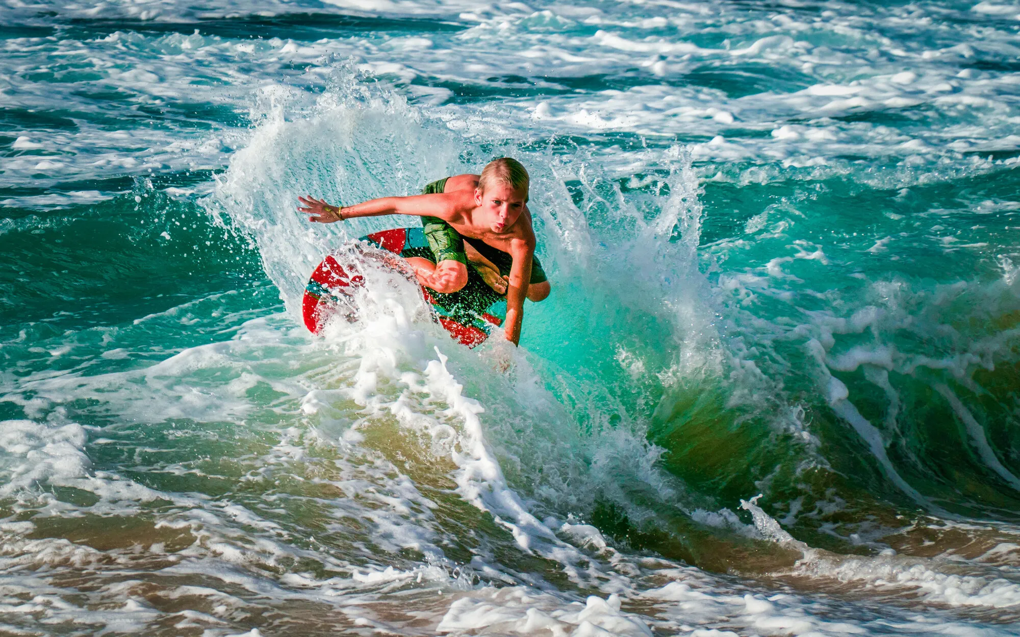 Surfer carving through a breaking wave